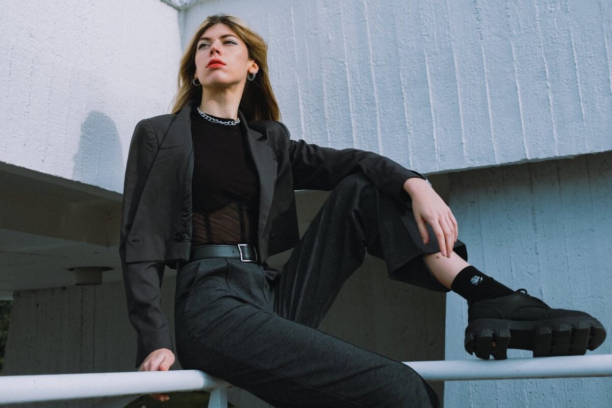 Fashionable woman in a suit sitting outdoors showcasing a modern style in Berlin.