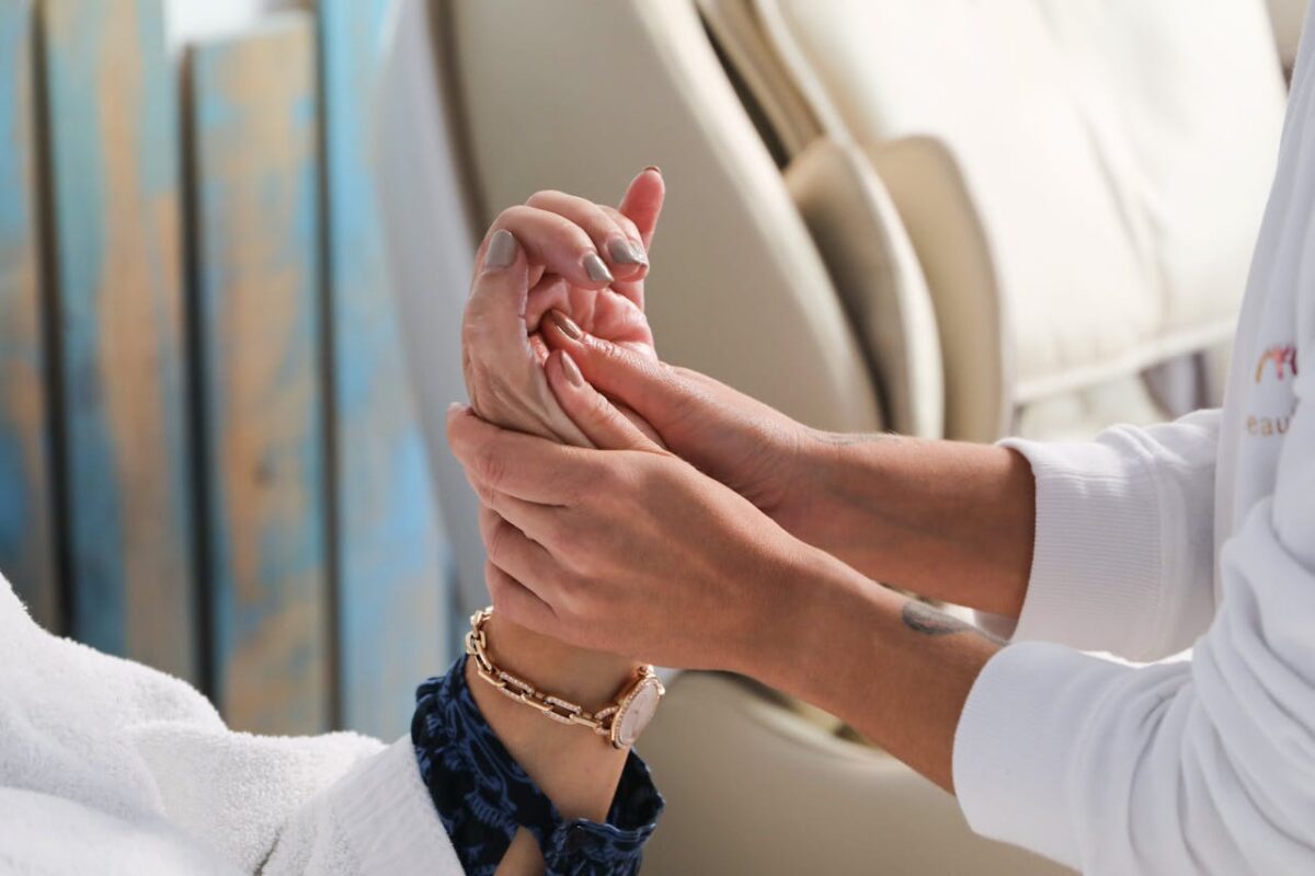 A therapist gently massaging a client's hand in a serene spa setting, promoting wellness and relaxation.